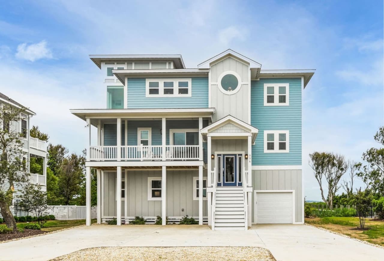 Charming coastal exterior w/ inviting porch & classic beach-house character.