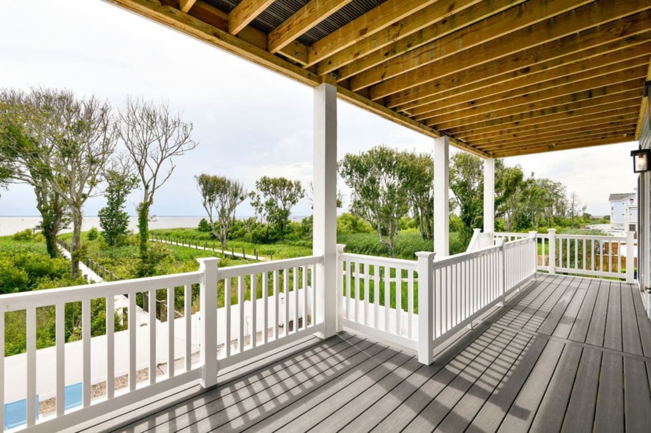 Breezy covered porch w/ rocking chairs, perfect for slow mornings & evening chats.