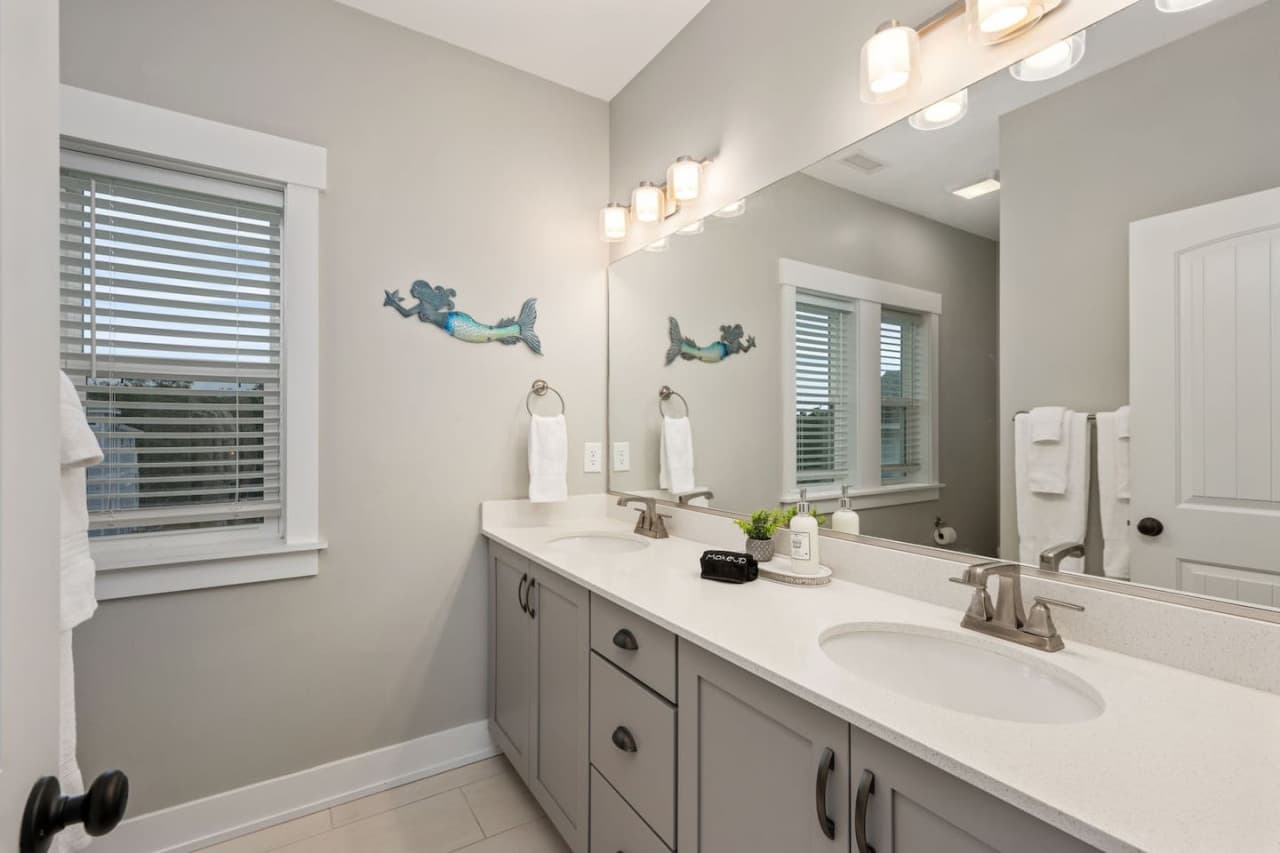 Clean, bright bathroom w/ double vanity, coastal touches & plenty of counter space.