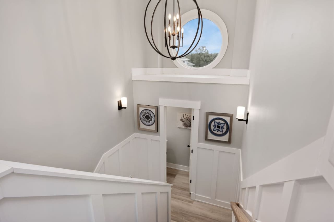 Staircase detail w/ clean lines, coastal art & natural light throughout.