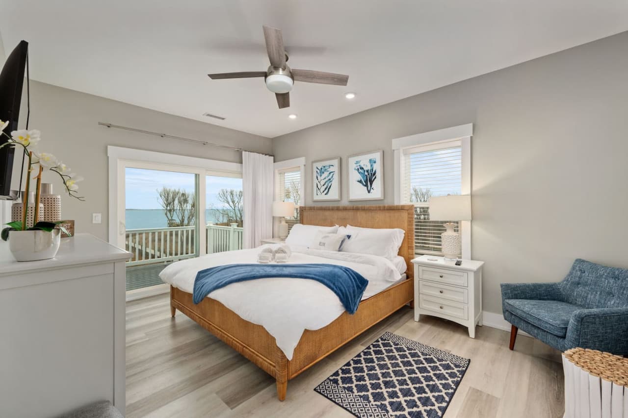 Comfortable bedroom w/ soft linens, natural light & a calm, coastal feel.
