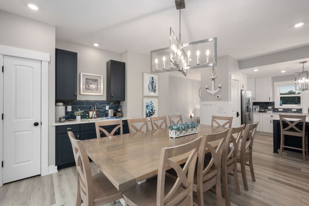 Open dining area w/ chandelier lighting, flowing seamlessly into the kitchen.