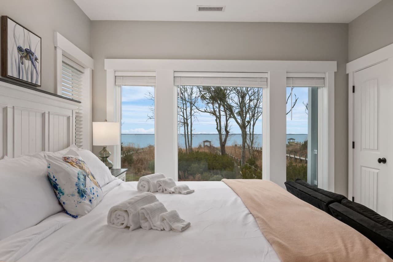 Bedroom w/ sliding doors to a private deck & open sound views straight from the bed.