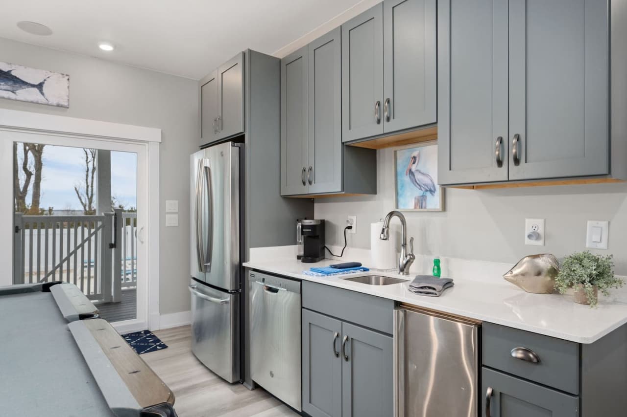 Second kitchenette w/ gray cabinetry, full-size fridge, dishwasher & coffee maker.