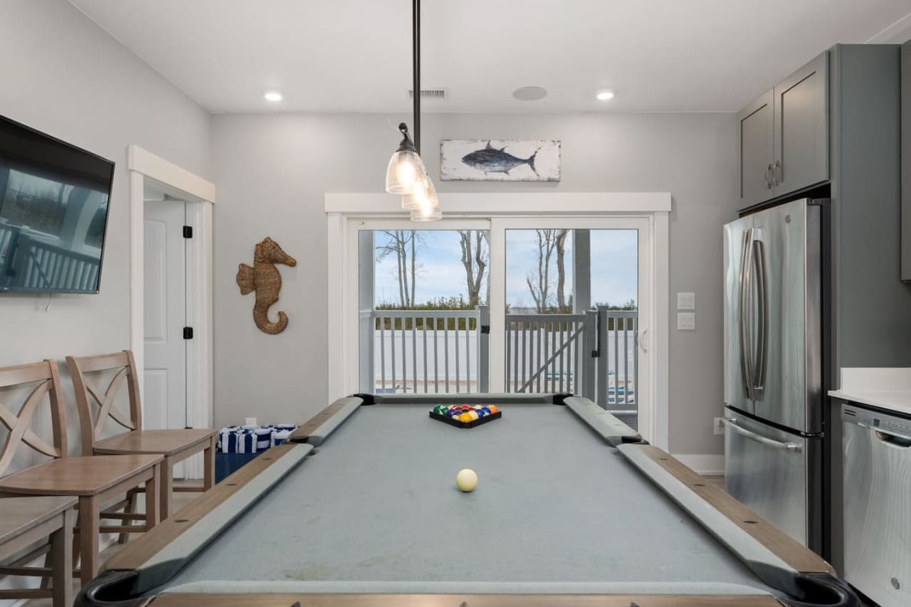 Game room w/ pool table, bar seating & a full fridge for keeping drinks close by.