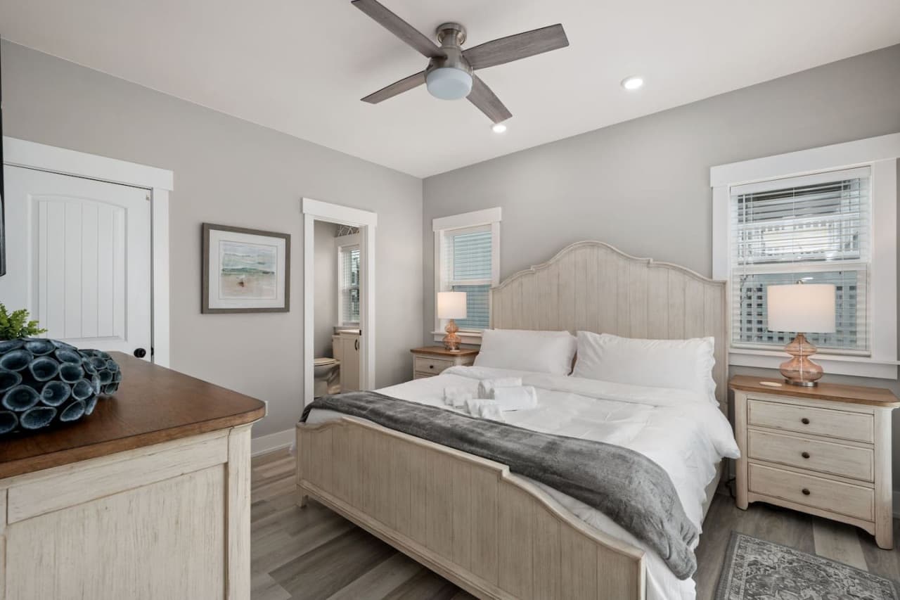 Bedroom w/ arched headboard, twin nightstands & an ensuite bath just through the door.