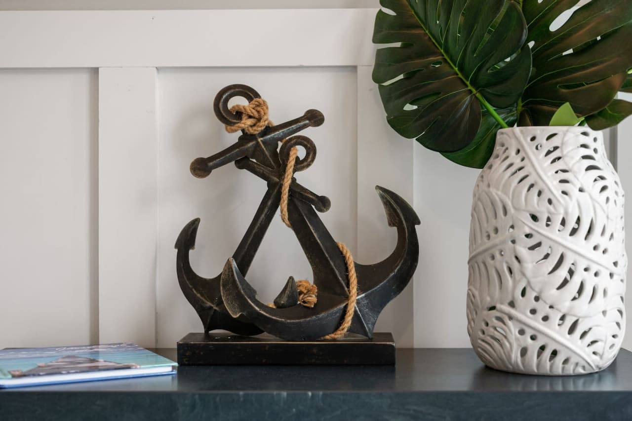 Nautical detail w/ an anchor sculpture & palm fronds on the entry console.