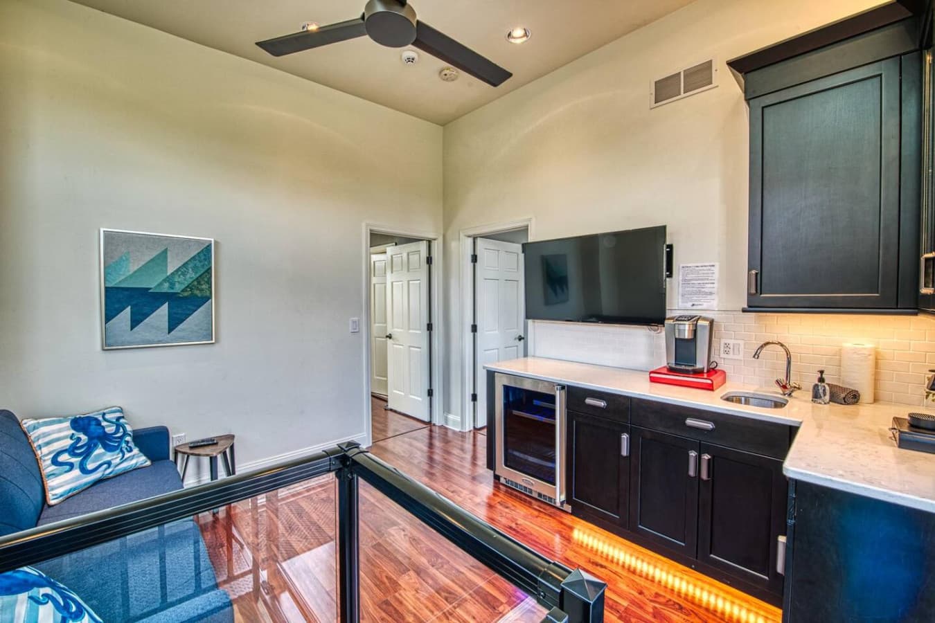 The Media Loft  features a custom wet bar, beverage center, and coffee station. Sliding patio doors open to the East Overlook Deck. There is a wall-mounted 50in HD Smart TV  and a full-size sofa bed.