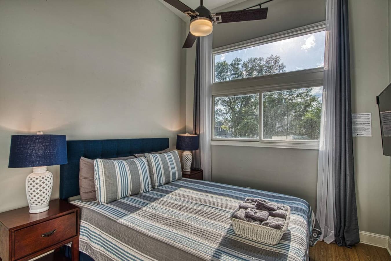 First floor queen bedroom has a wall-mounted, 50in Smart HDTV, ceiling fan and large closet.