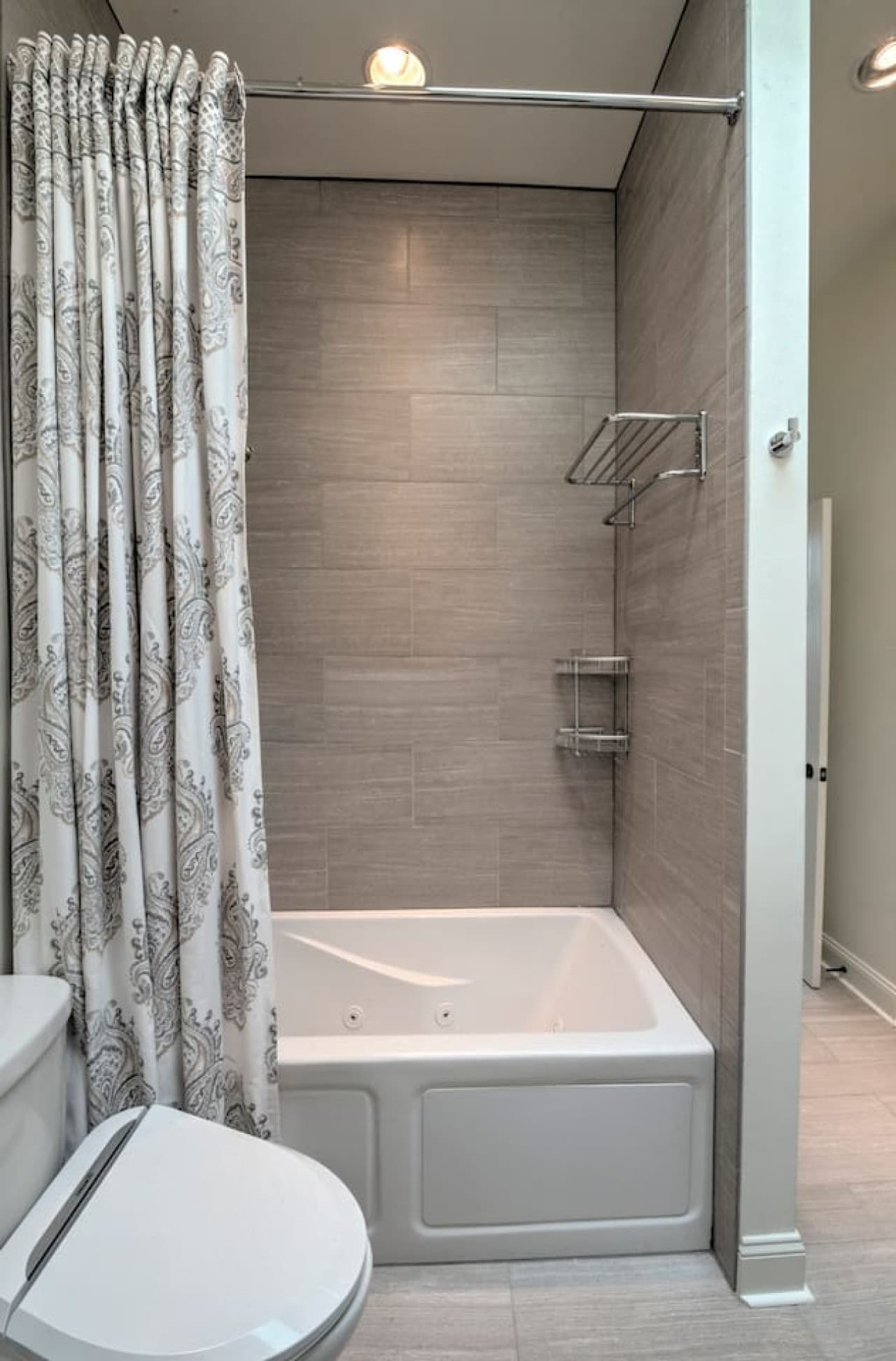 The 2nd floor bathroom features a jetted tub, heated tile floors and towel bars, a dual vanity, and skylight.