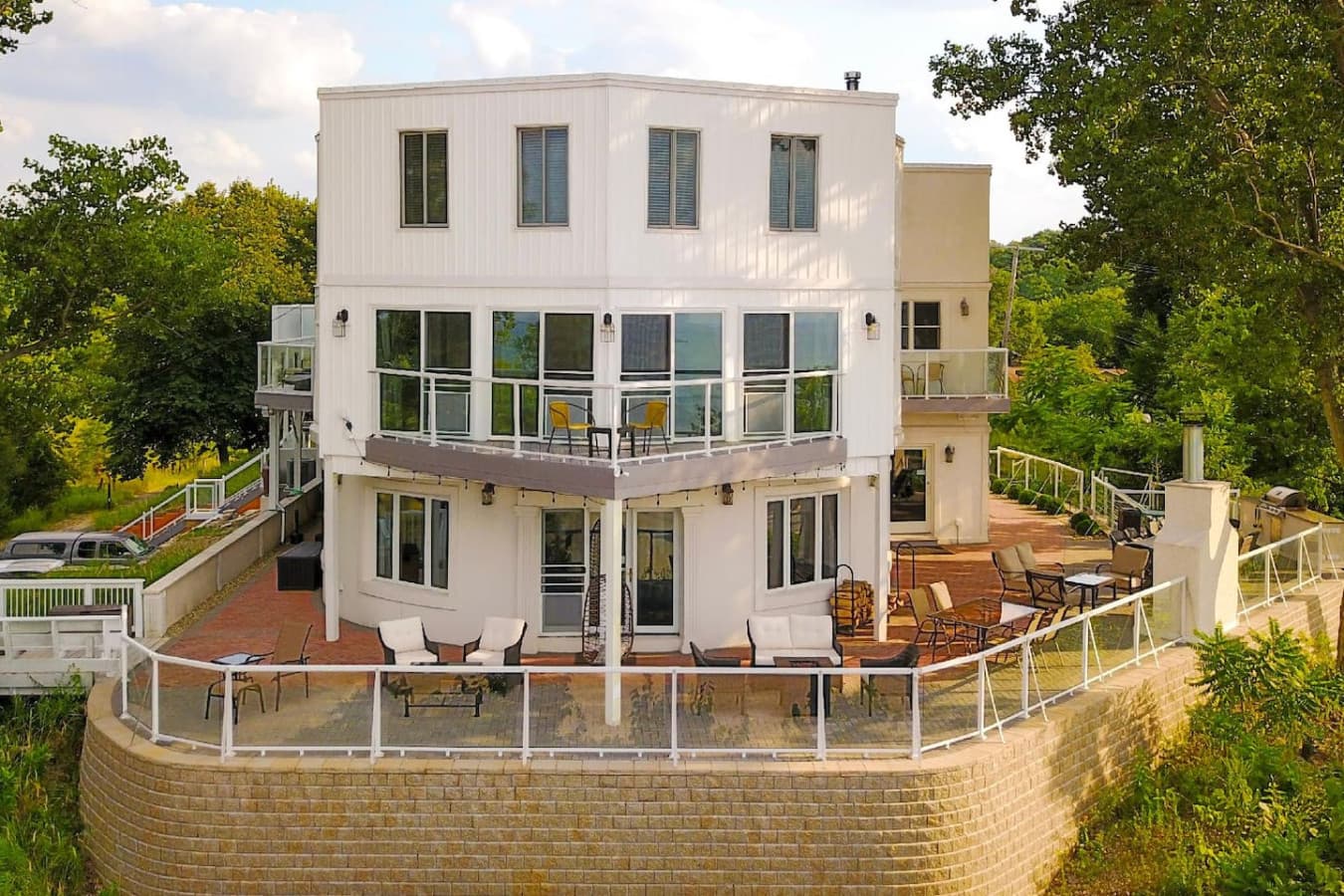 Enjoy 4000 sqft of outdoor entertaining featuring seasonal furniture, an outdoor fireplace, a built-in grill, a covered hot tub, dining, and beach access from our private stairs