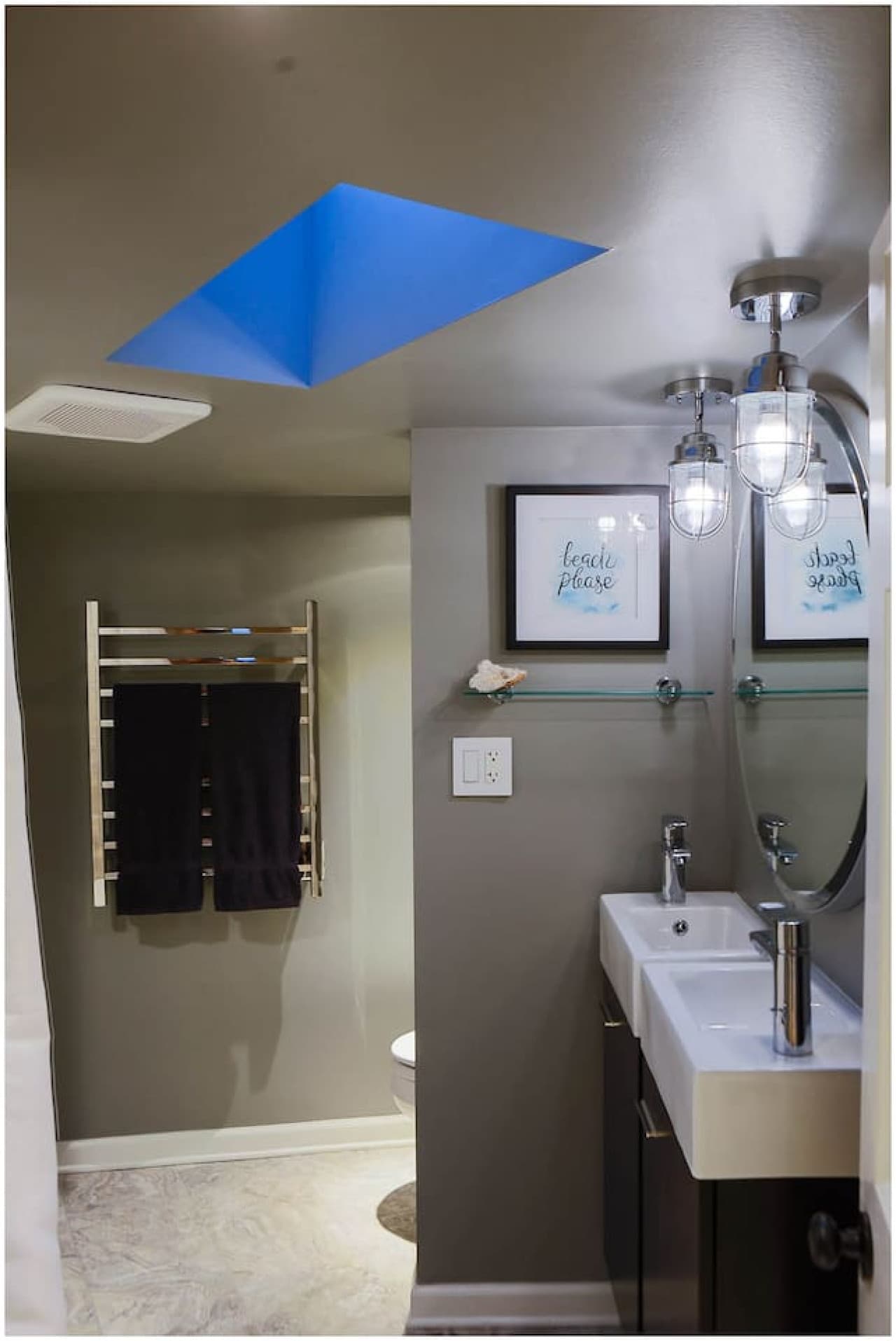 Nautical Suite Bath features heated stone floors & towel bars, dual vanities, and skylight.