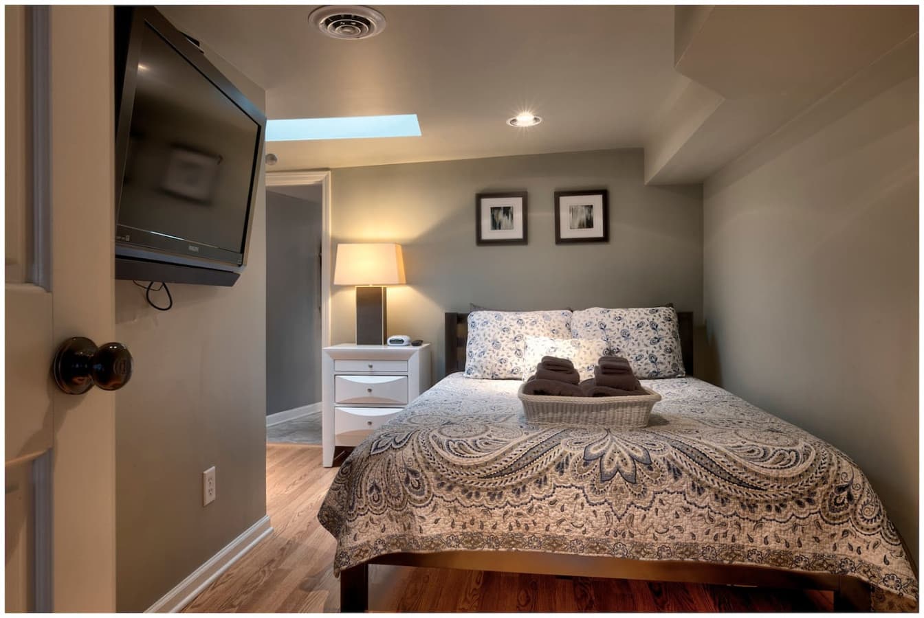 The Skylight Bedroom on Level 3 features a queen bed, Smart TV, beautiful natural light from the overhead skylight, and direct access to a full bathroom, shared with the adjacent Nautical Suite