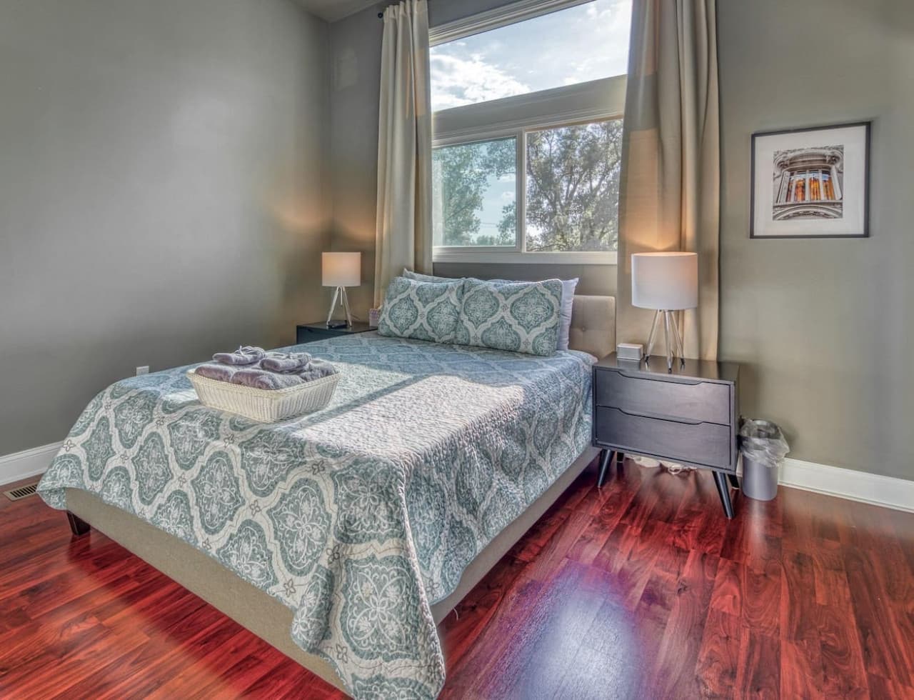 Second floor Queen Bedroom has sunset and partial Chicago skyline views, shared en-suite access, and a wall-mounted 50in Smart HDTV.