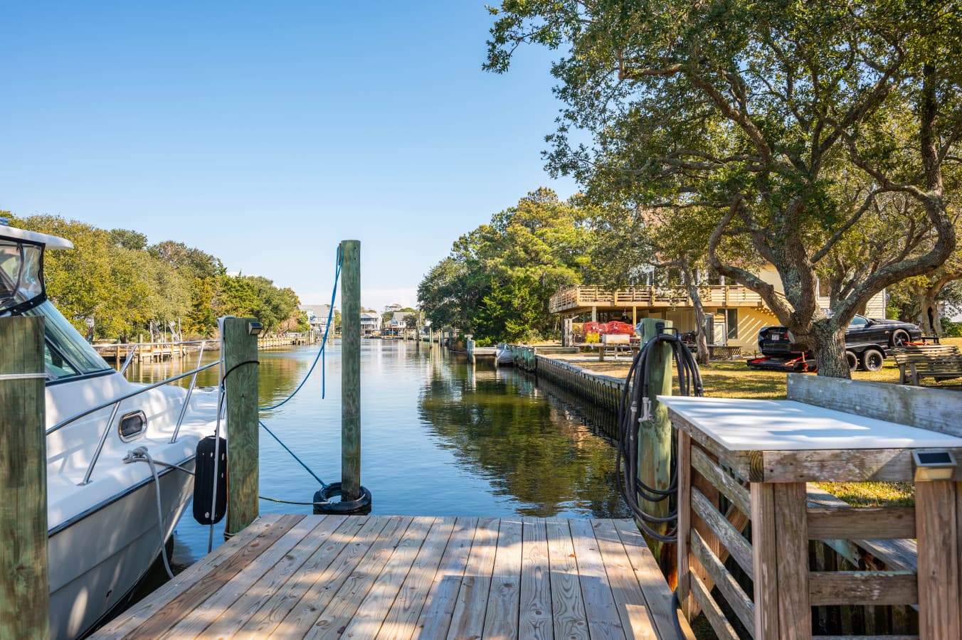 Dockside canal scene w/ boats and calm water, ideal for soaking in the coastal atmosphere.