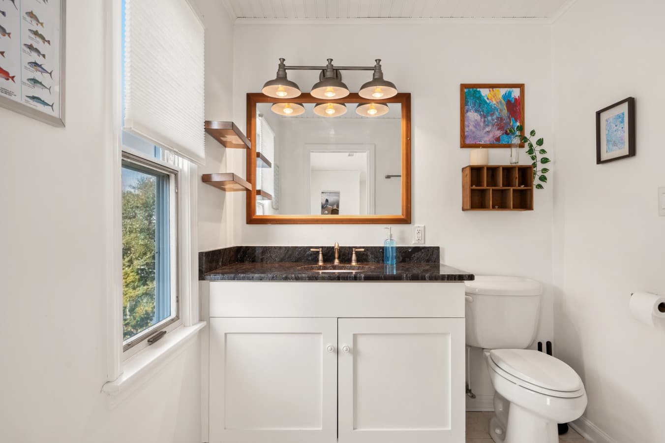 Bright bathroom w/ classic vanity, polished countertop, & warm lighting for an easy, refreshed start to the day.