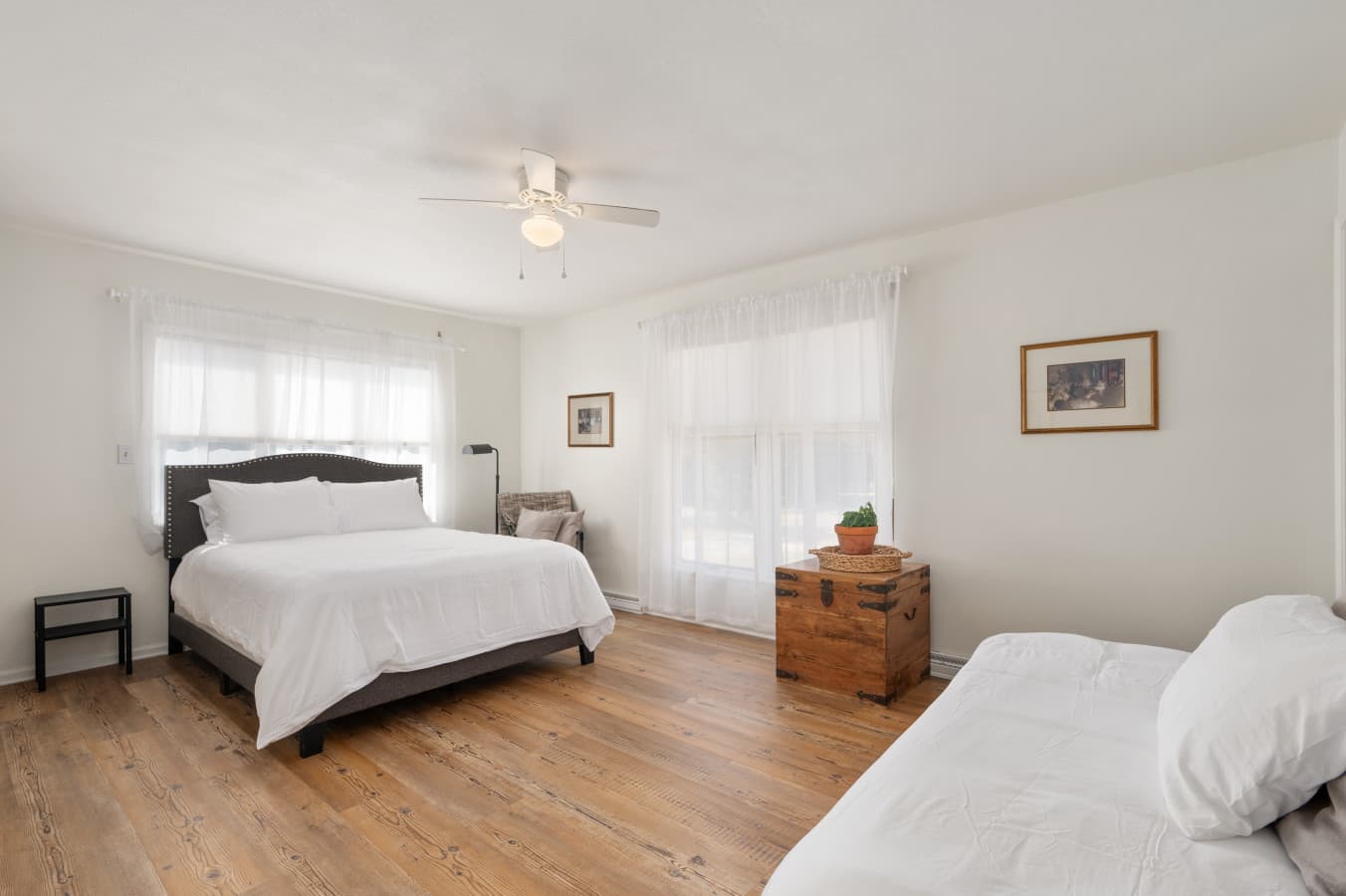 Large bedroom w/ a comfortable bed, ceiling fan, & open space to unwind and relax.