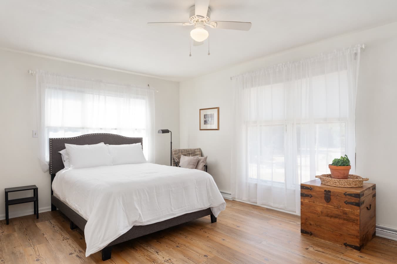 Airy bedroom w/ a cozy bed and large windows, creating a calm, light-filled retreat.