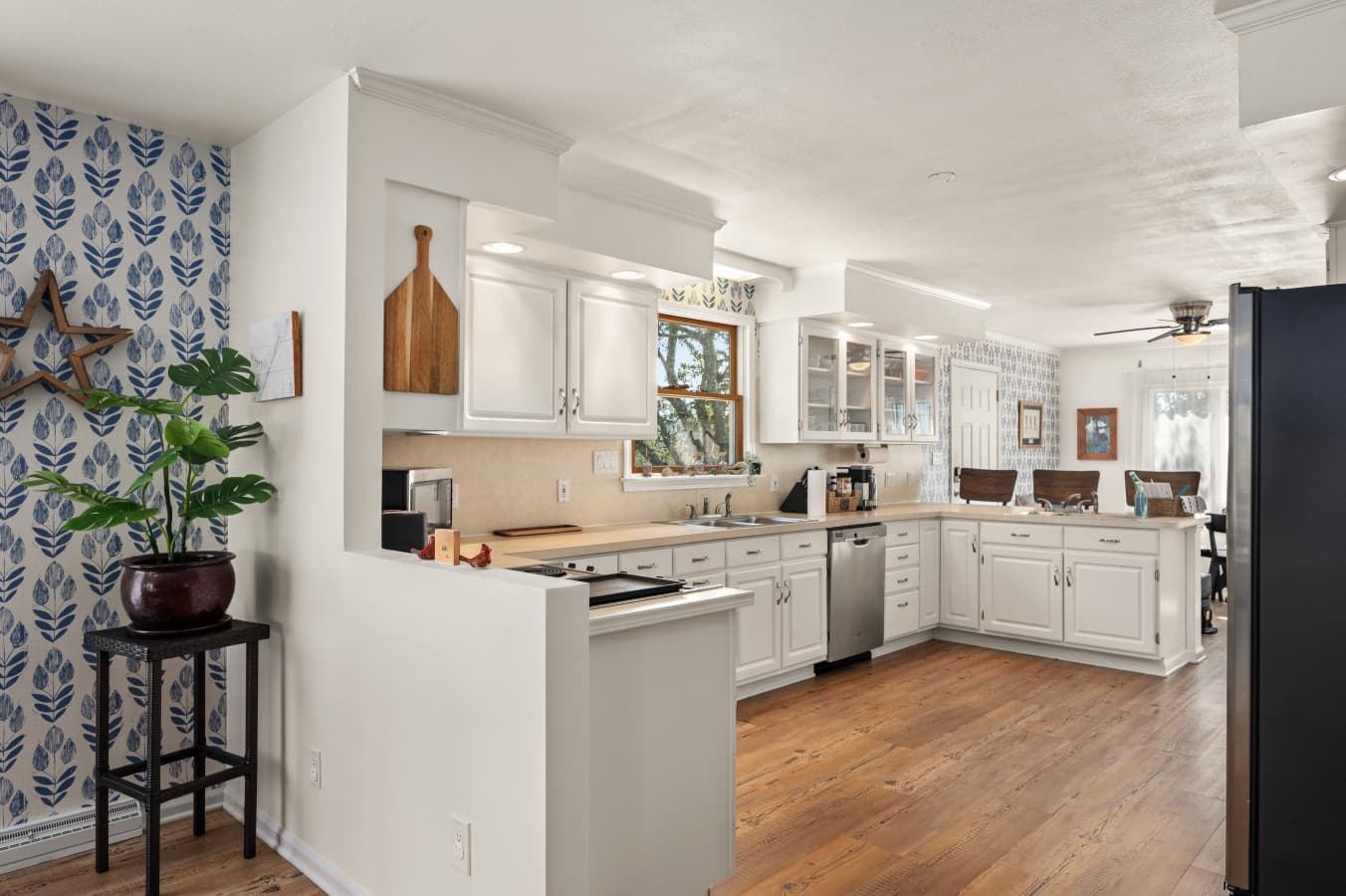 Open kitchen w/ white cabinetry and ample counter space, ideal for easy meals at home.