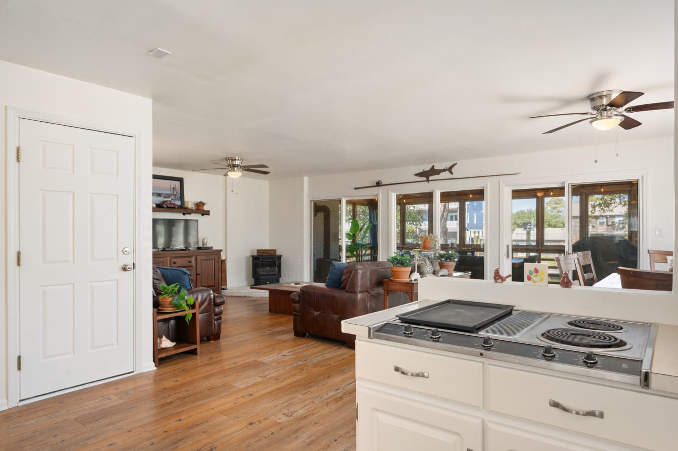 Open living space w/ kitchen island, comfy seating, & large windows that fill the room w/ light.