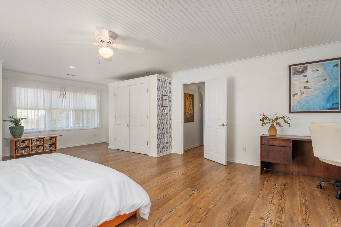 Wide open room w/ wood floors, ceiling fan, & flexible space to relax or gather.
