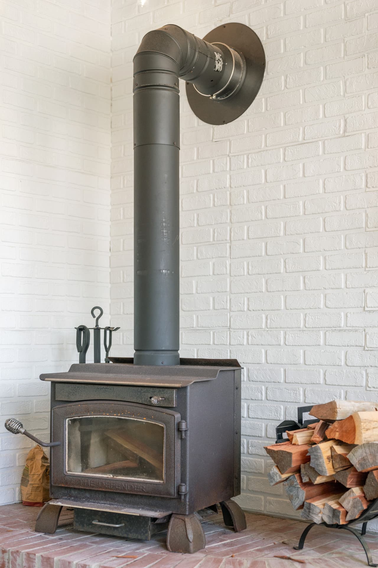 Charming brick fireplace w/ wood stove insert, adding warmth and character to the space.