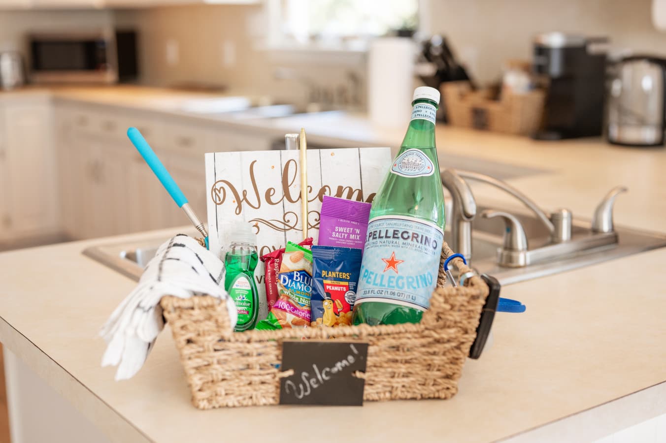 Welcome basket detail w/ snacks & sparkling water set out on the kitchen counter.