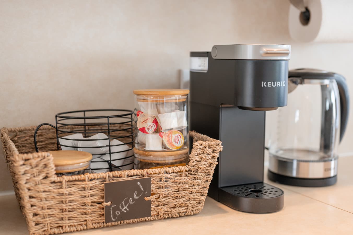 Coffee station detail w/ Keurig brewer, electric kettle & a basket of supplies for slow mornings.