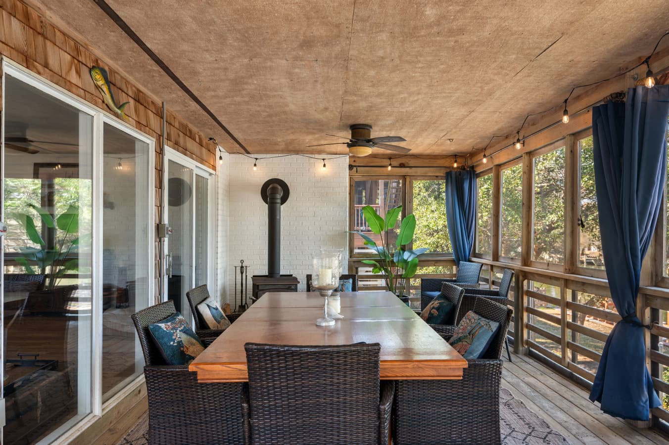 Covered outdoor seating area w/ ceiling fan & dining table, ideal for laid-back mornings or evenings.
