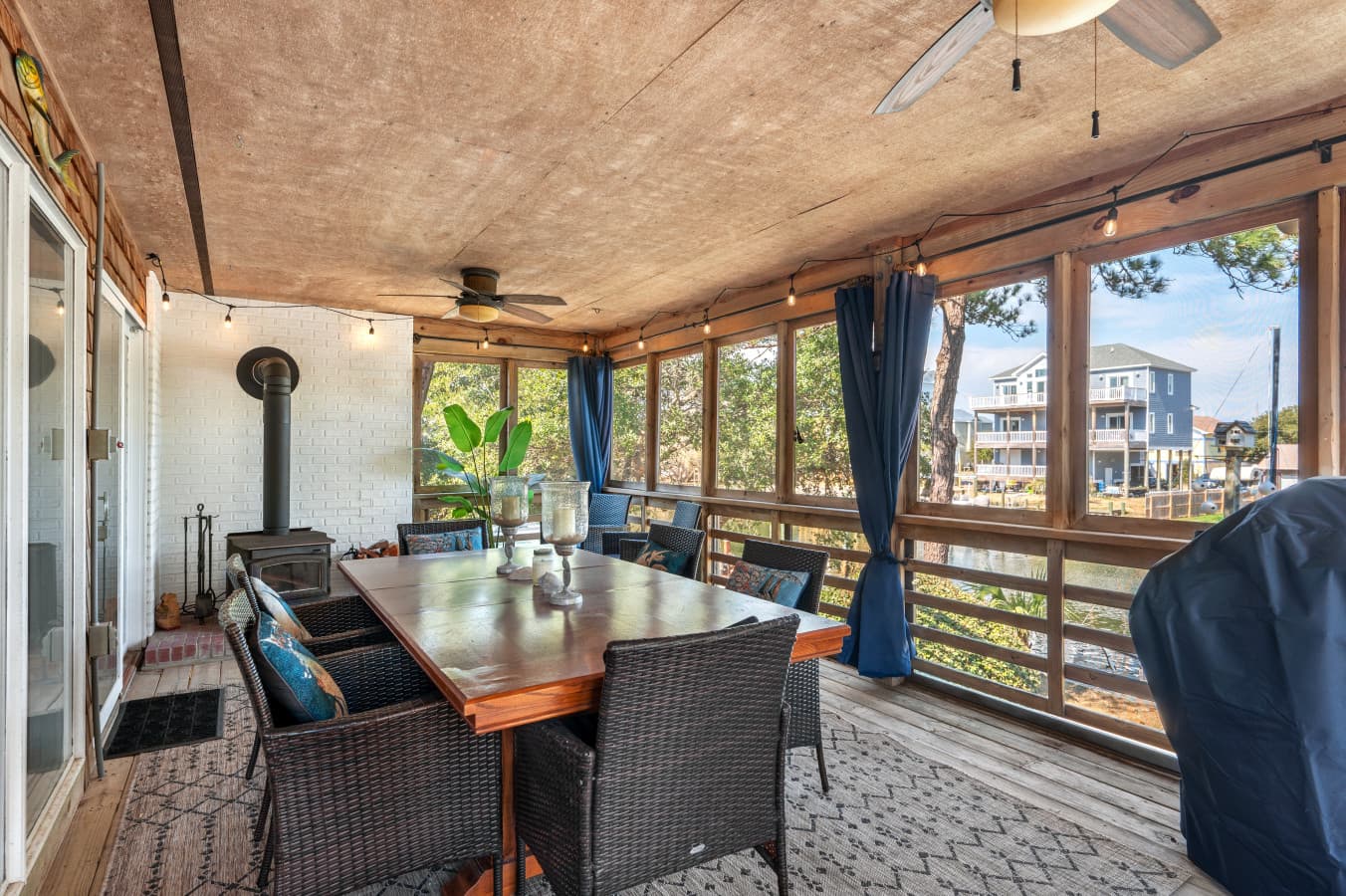 Screened porch w/ cushioned seating & dining table, perfect for breezy mornings and relaxed evenings.