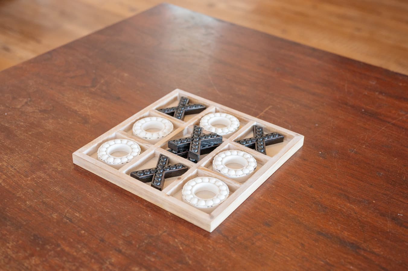Shell tic-tac-toe board on a wood table, an easy game between beach trips.