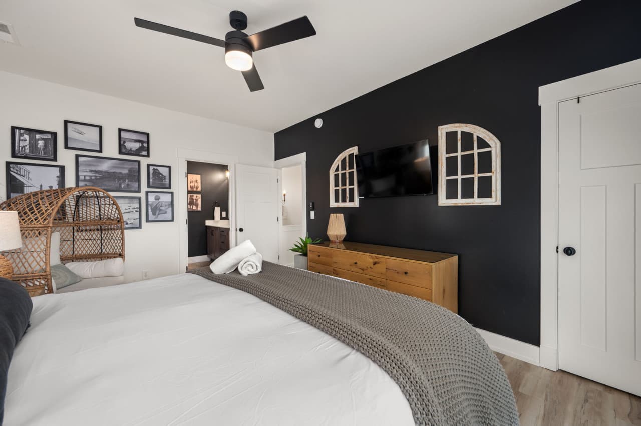 Stylish bedroom w/ bold accent wall, cozy bedding & personal touches for a relaxed stay.