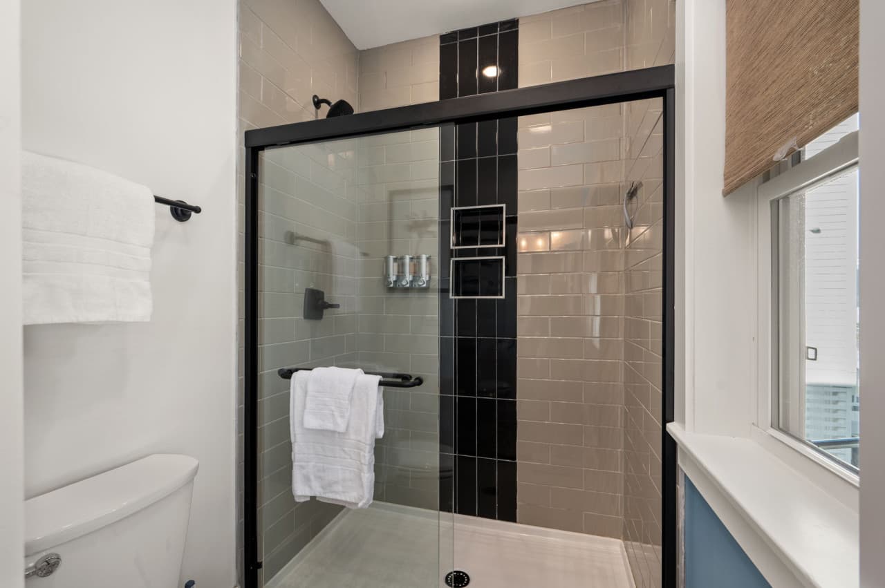 Glass-enclosed shower w/ dark tile accents for a polished, modern look.