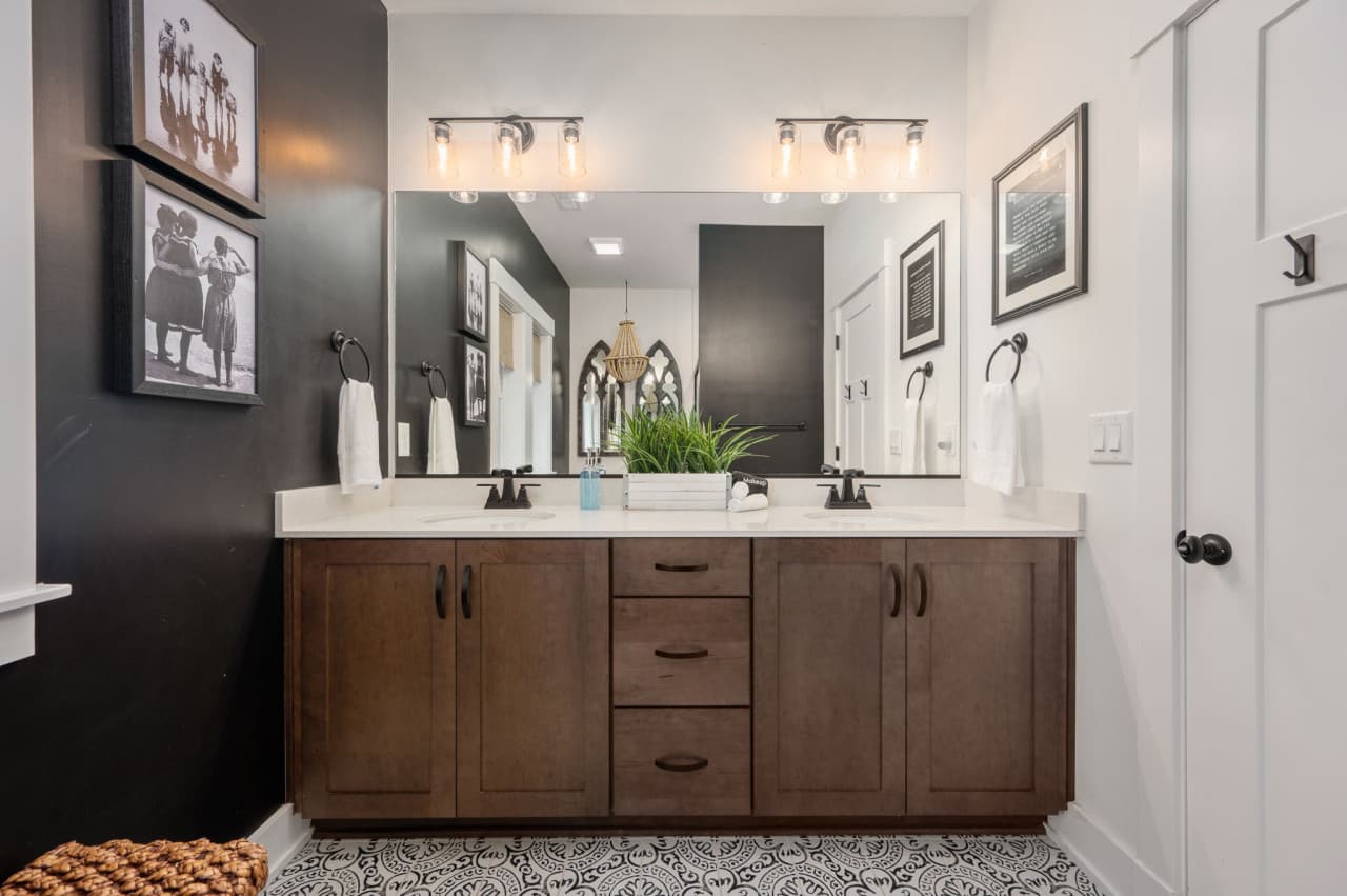 Spacious double vanity w/ warm wood tones & modern fixtures for easy mornings.