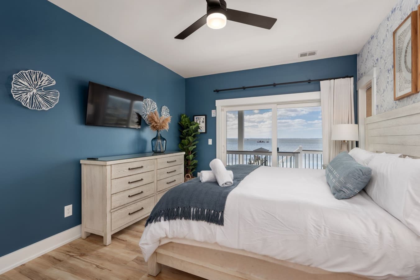 Serene bedroom w/ blue accent wall, layered textures & soft light for restful nights.