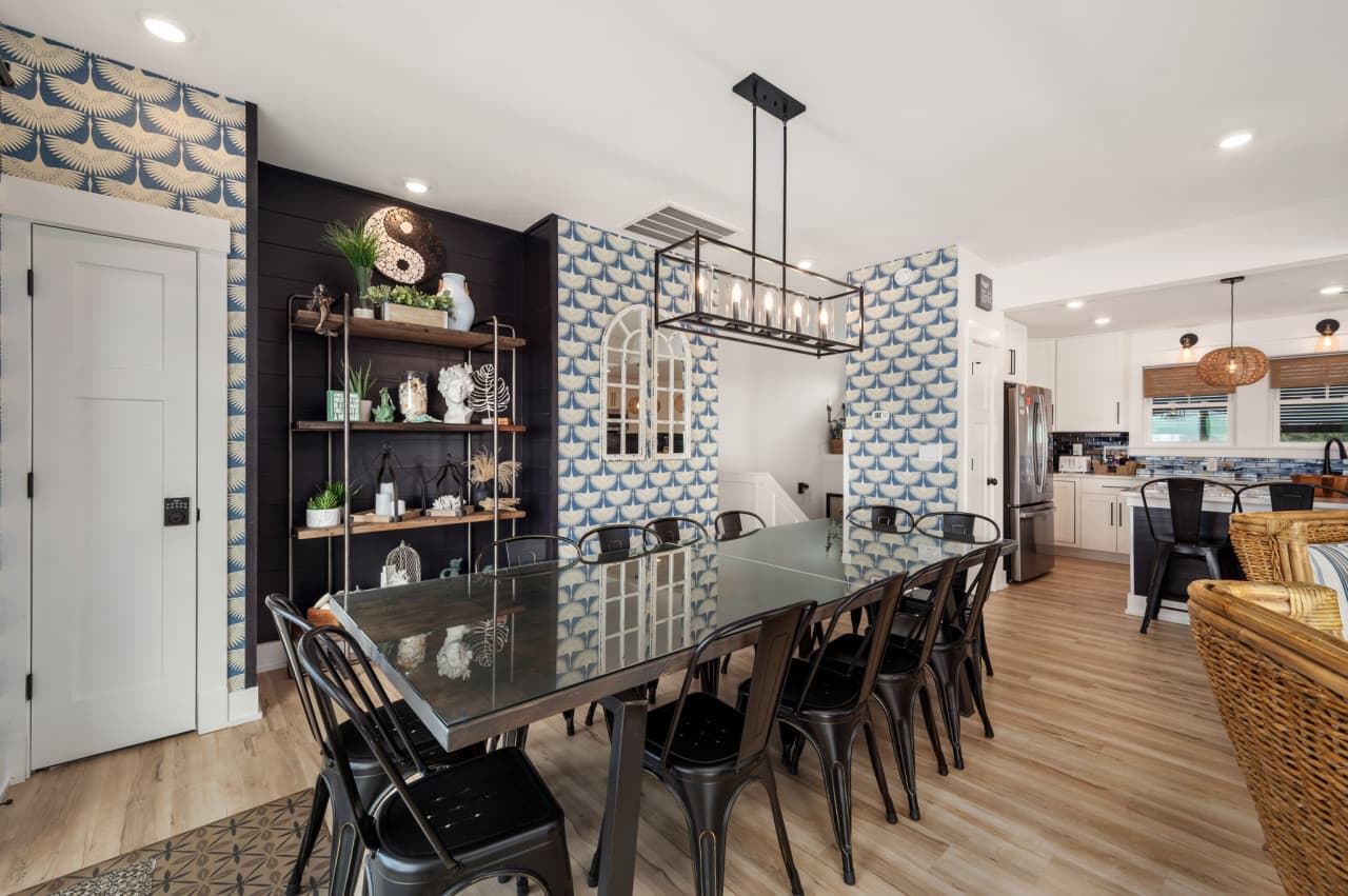 Open dining area w/ long table, statement lighting & easy flow to living spaces.
