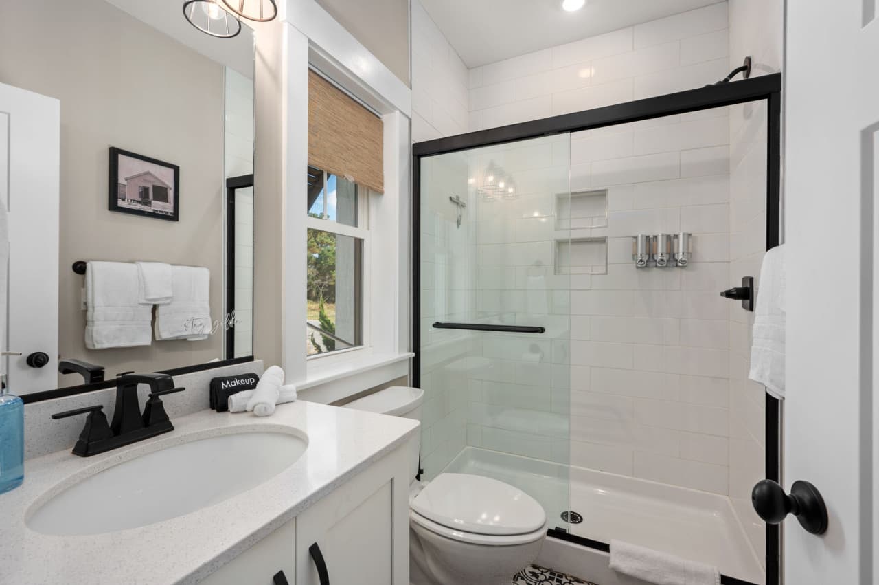 Bright bathroom w/ glass shower, clean lines & modern fixtures.