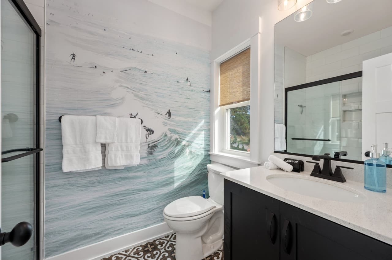 Fresh bathroom w/ tiled shower, crisp linens & a clean coastal look.