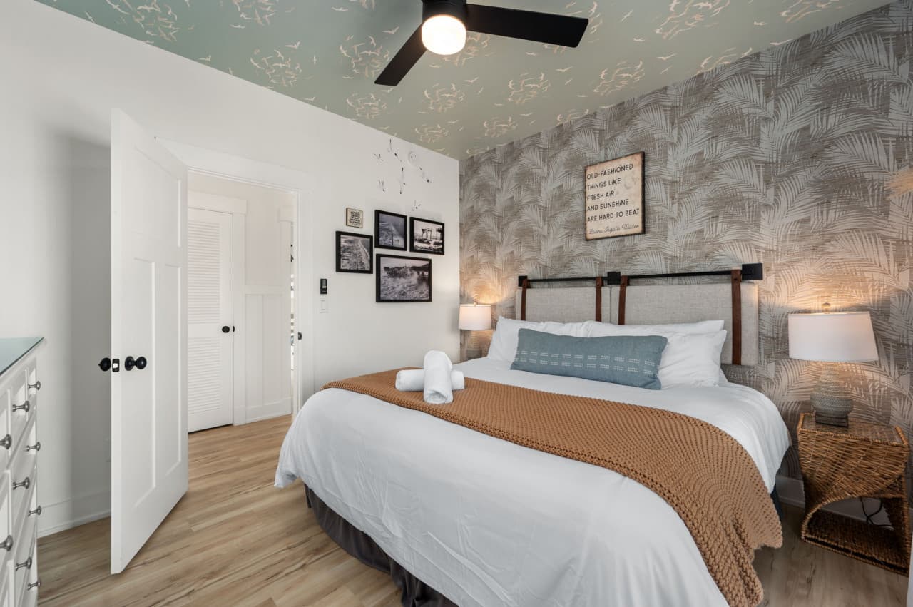 Inviting bedroom w/ textured accent wall, soft linens & a peaceful, tucked-away feel