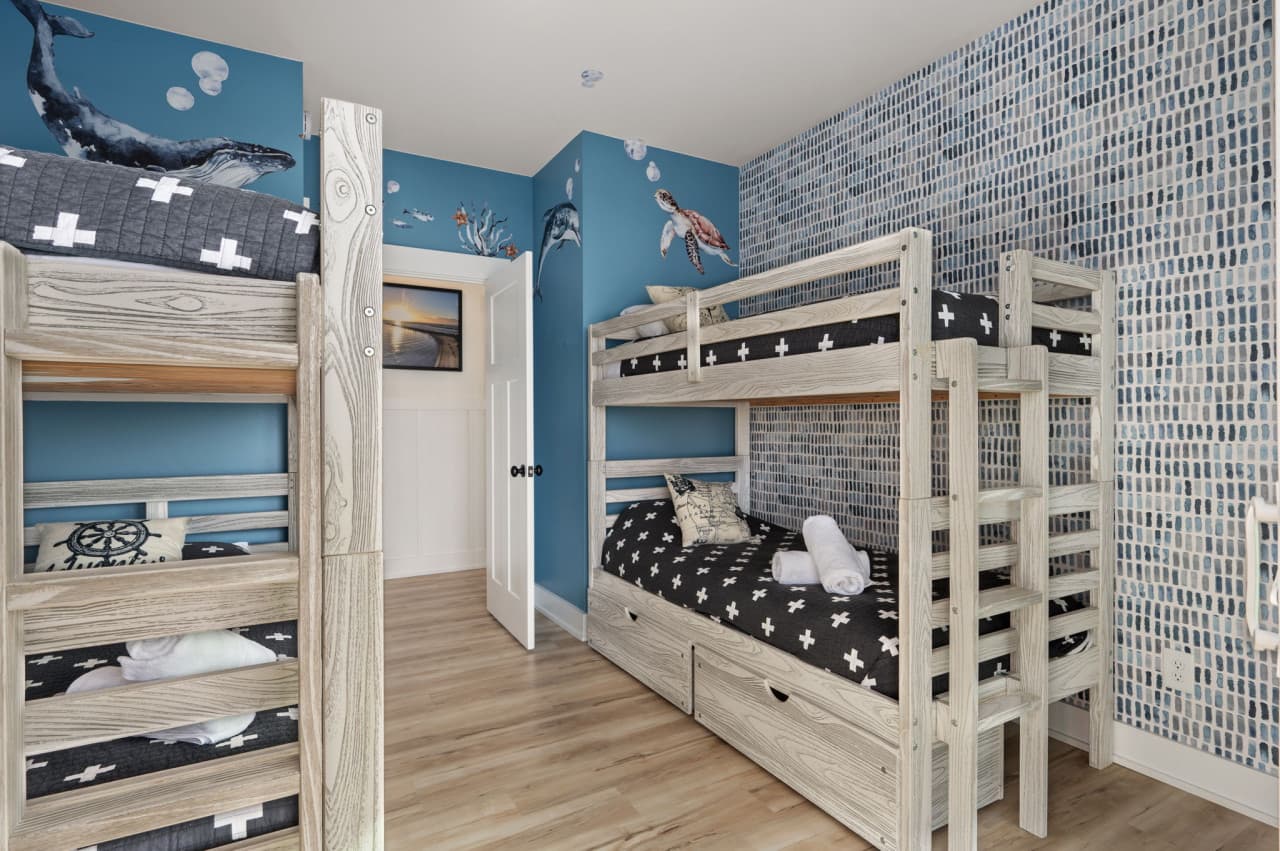 Kids' bunk room w/ two bunk beds, whale artwork & floor space to spread out and play.