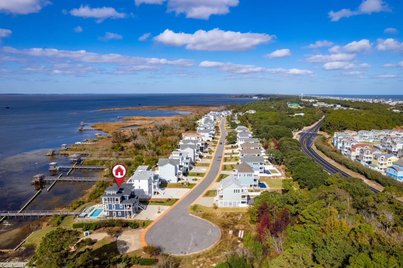 Aerial of the home's stretch of shoreline w/ the pool below and the sound beyond.