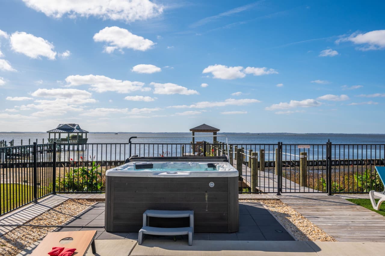 Hot tub on the pool deck w/ the sound and the covered pier in full view.