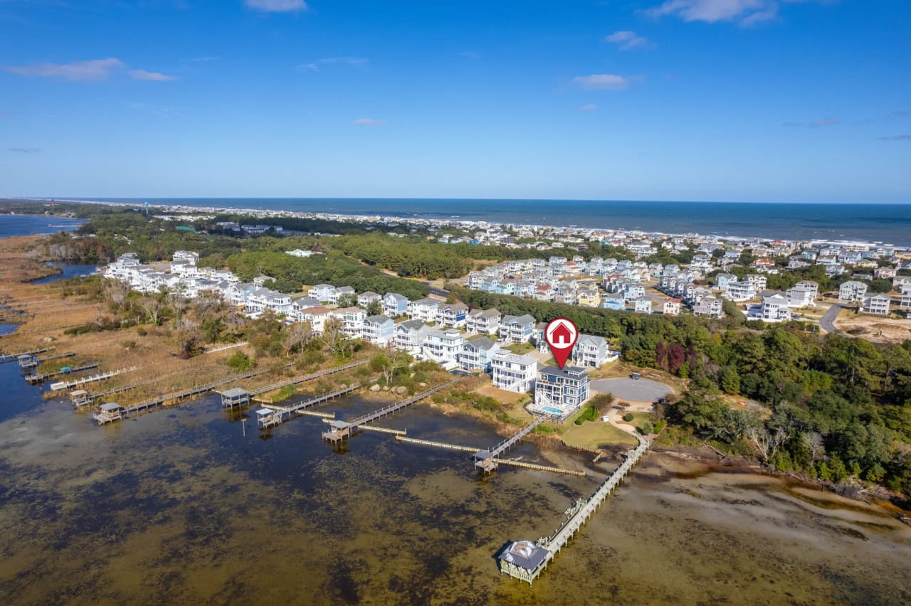 Aerial w/ the home marked among the soundfront homes, marsh and open water around it.