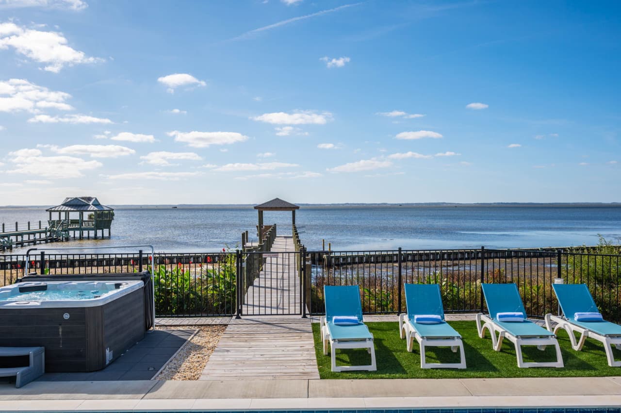 Hot tub & loungers at the lawn's edge w/ the pier and open sound just beyond.