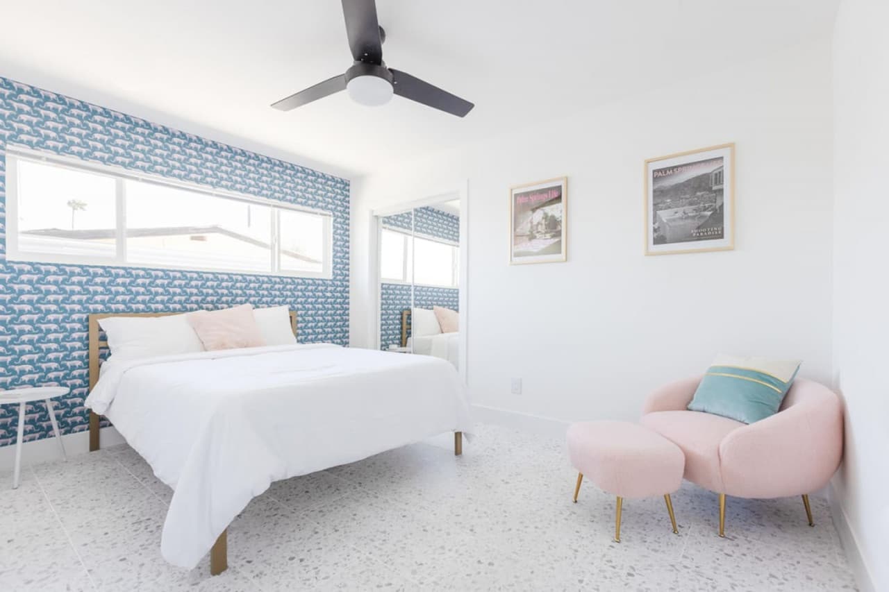 Snooze in style in our queen-sized bed, set against a backdrop of vibrant blue, leopard-inspired wallpaper.
