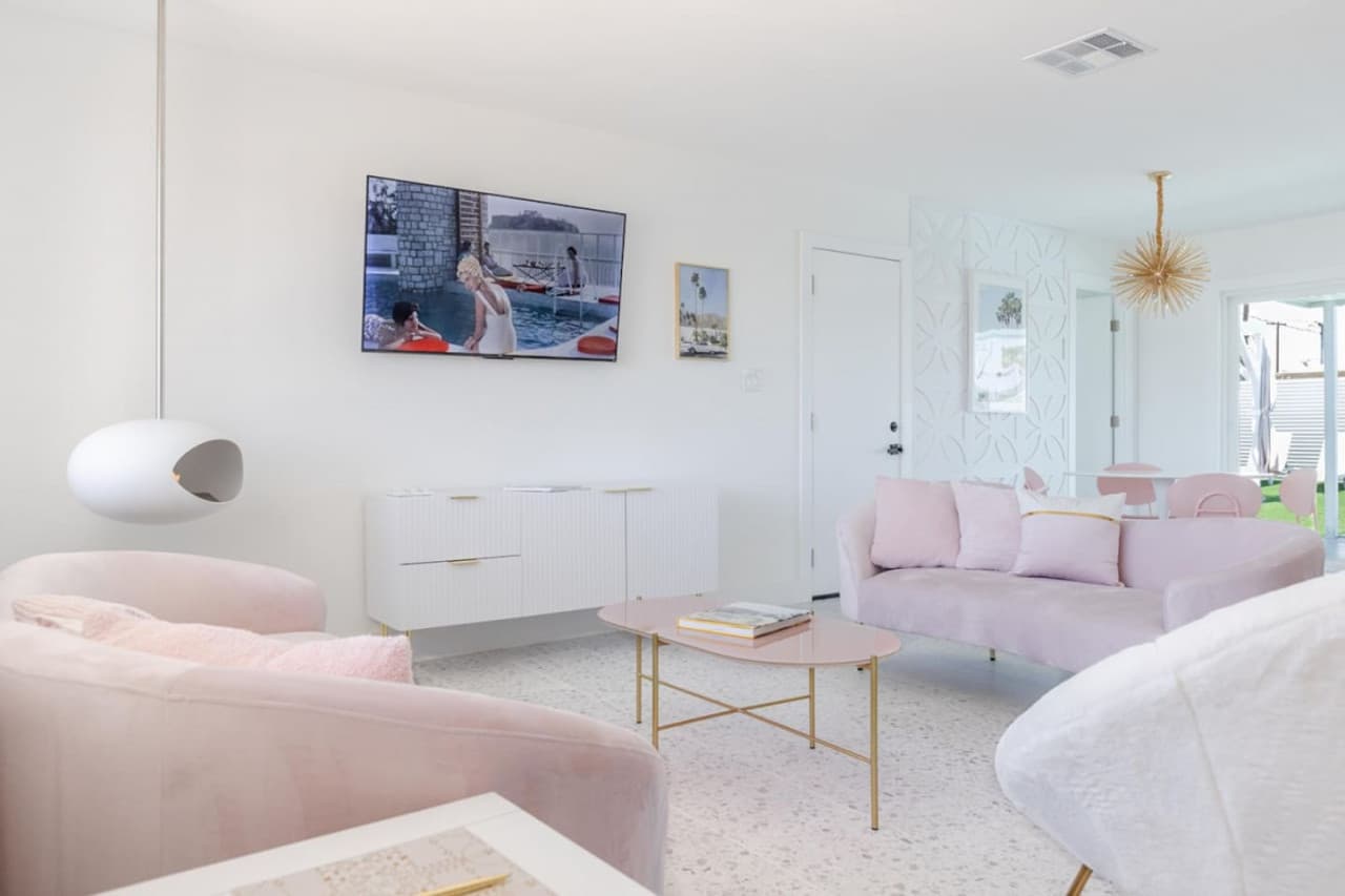 Indulge in our pink-inspired haven, complete with cozy pink couches, a one-of-a-kind indoor fire pit, and all the tech you need with our smart TV.