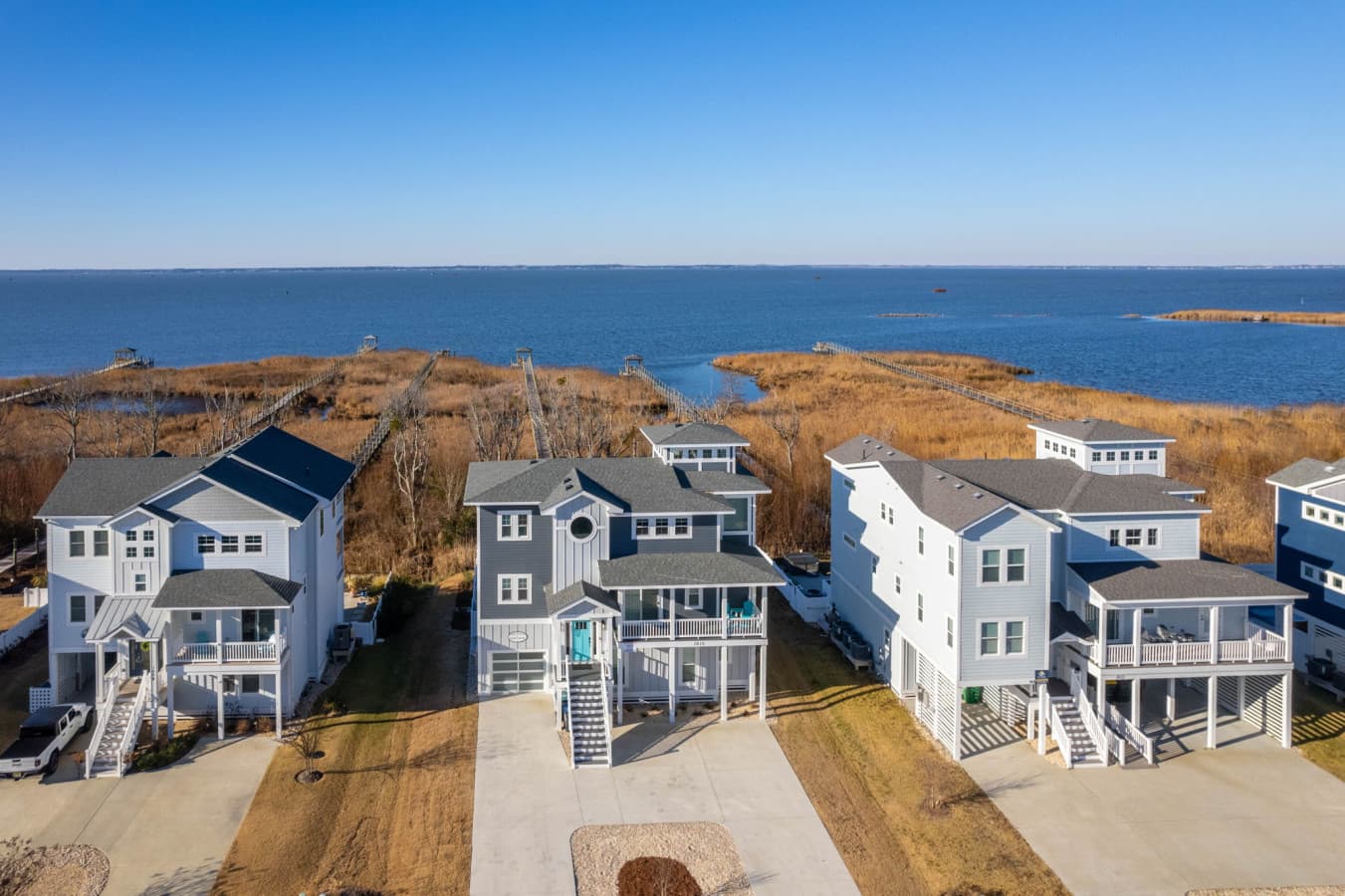 Sweeping aerial view of the shoreline & surrounding homes set against open water