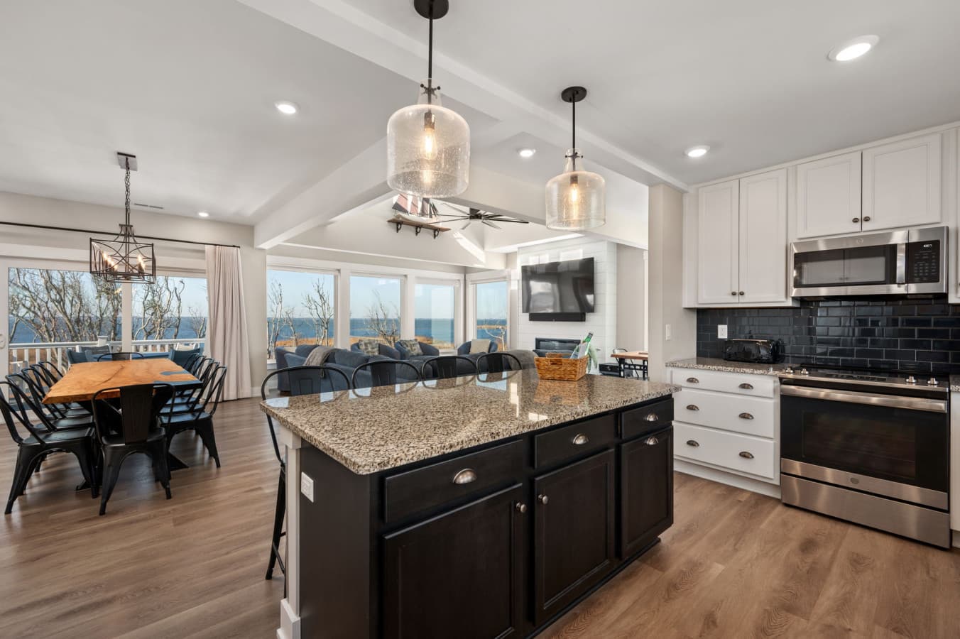 Sleek, open kitchen w/ large island, bar seating, & bright finishes designed for easy group cooking