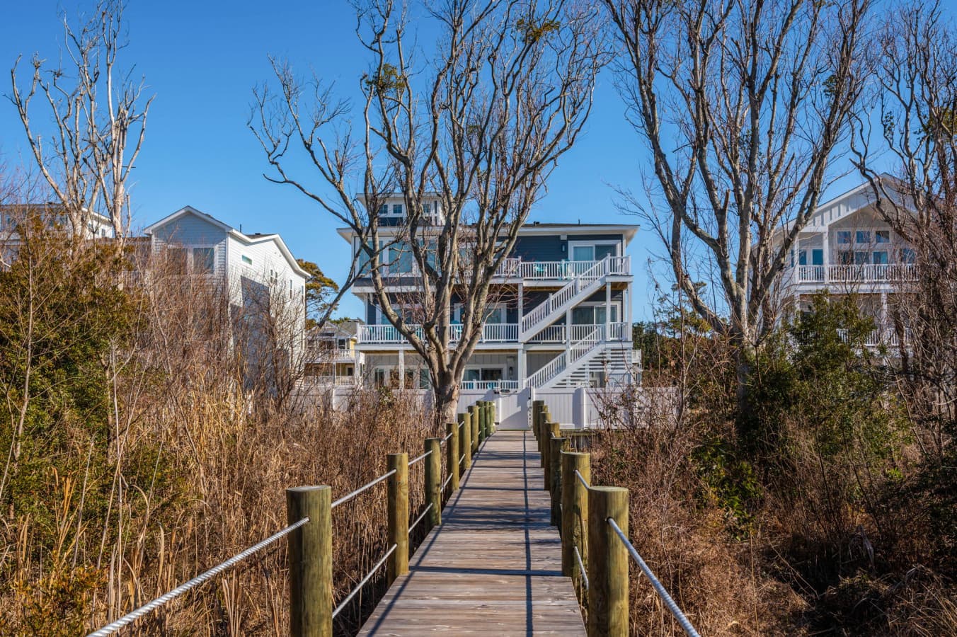 Scenic boardwalk path leading through natural marshland toward the water