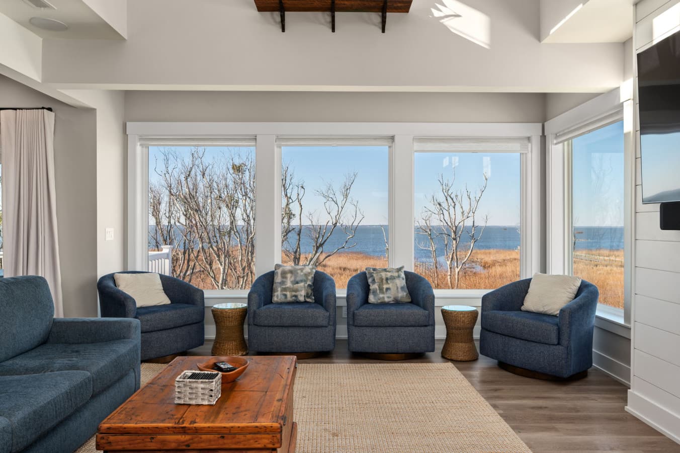 Cozy seating nook framed by large windows, perfect for conversation & quiet moments indoors